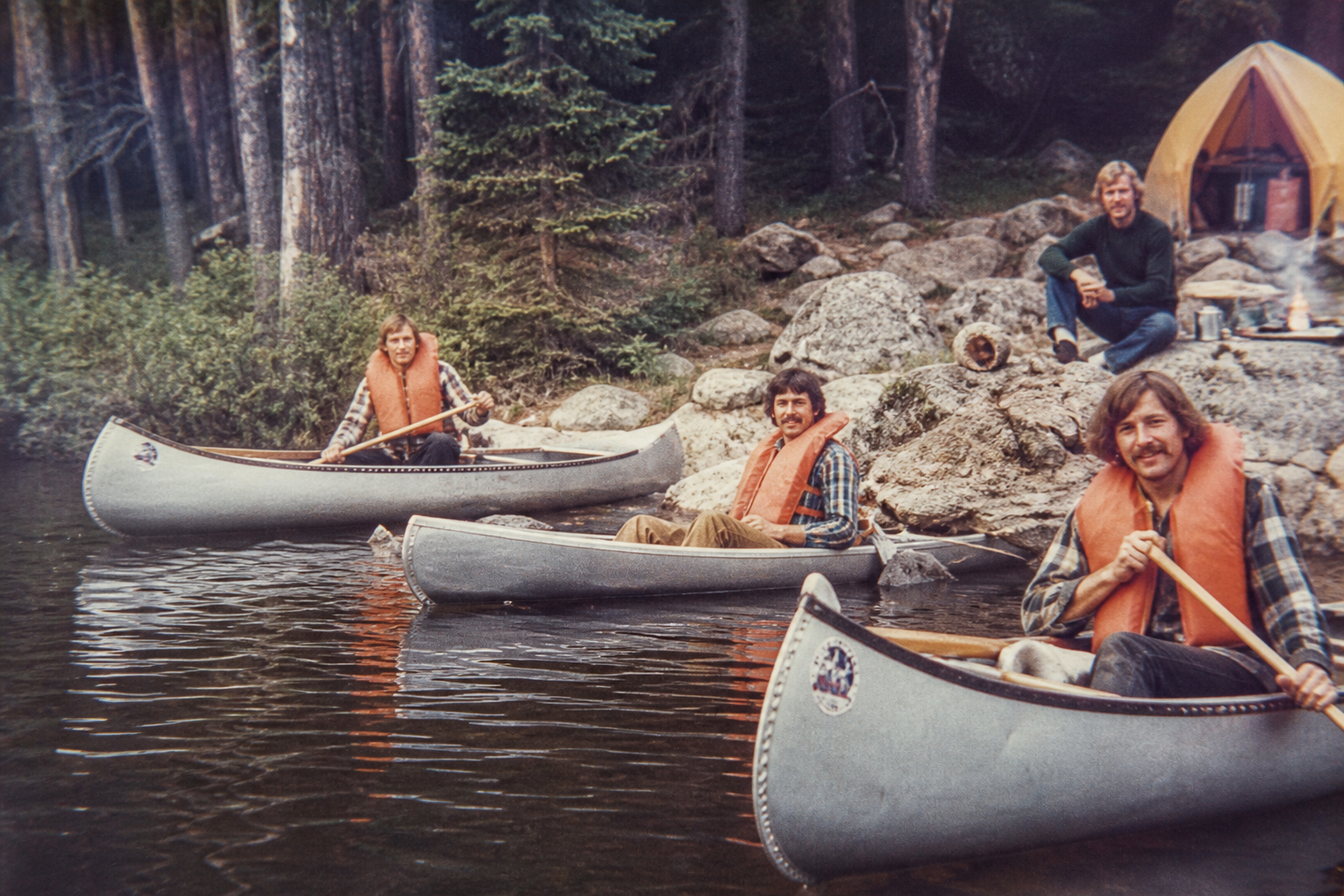 Men with aluminum Grumman canoes on a Northwest lake in the 1970s